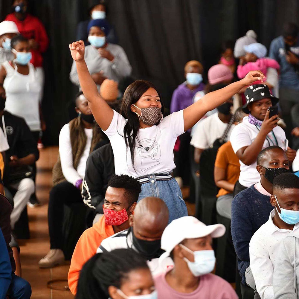 Young woman triumphant at EmpowaYouth summit with fists raised